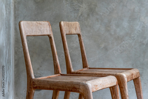 A Couple Of Chairs in front of a cement wall