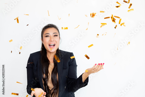 woman in suit blowing confetti. Studio shot 