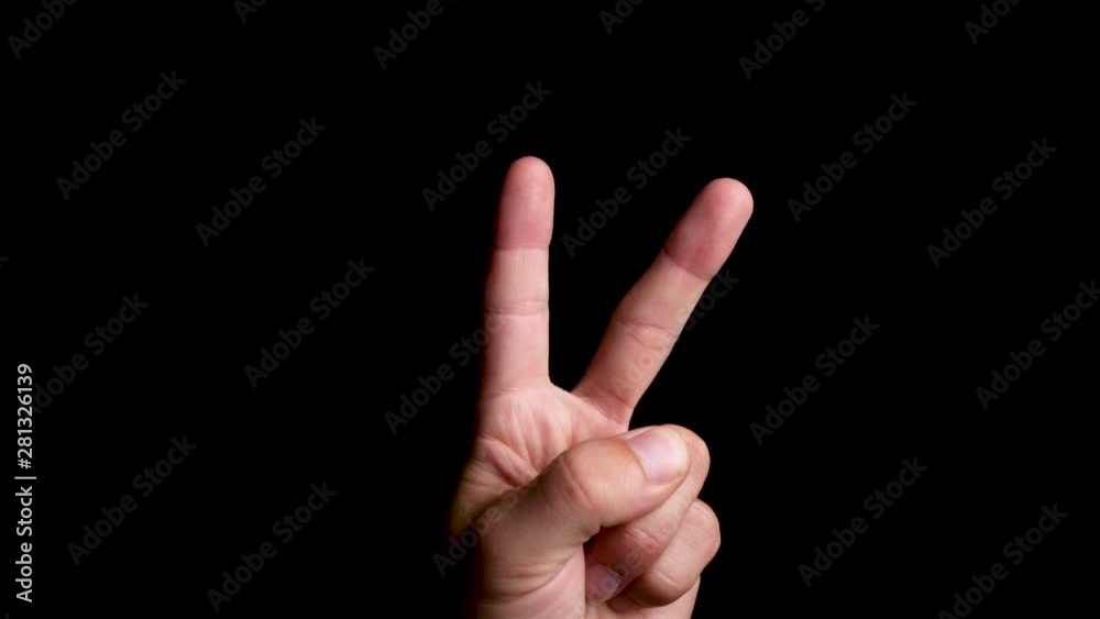 Peace hand symbol display on a plain black background, close up Peace hand symbol display on a plain black background, close up