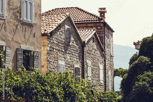 Old Town Budva, Montenegro. We see ancient houses, a very narrow street and great mountains