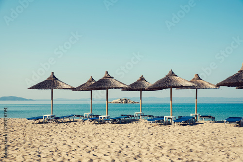 Beautiful beach in Greece Chalkidiki with straw umbrellas and no people Selective focus