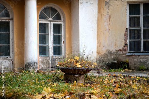 old flowerbed with dried autumn lea of an old manor house.  fragment of a house with a window and a door   of the abandoned ruined Manor .. estate Sukhanovo, Vidnoe, Moscow region, Russia. photo