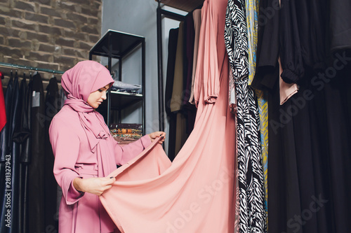 Arab woman in traditional Muslim clothes buys a new dress in an Oriental store. photo