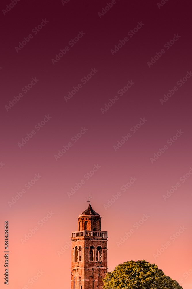 Venetian aged bell tower with cross and reddish bloody sunset, Venice, Italy, summer time