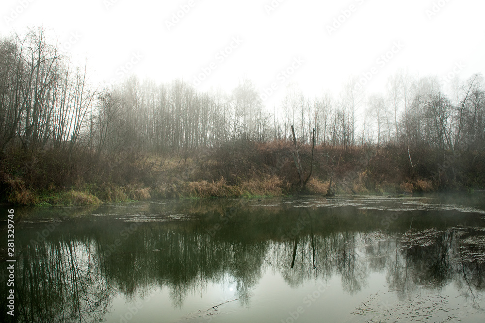 Forest landscape with a river. Early morning mist over the water. Autumn or spring landscape. Quiet, mystical place Forest landscape with a river. Early morning mist over the water. Autumn or spring landscape. Quiet, mystical place
