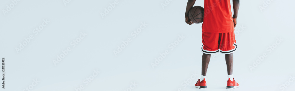 cropped view of african american basketball player holding ball on grey background, panoramic shot cropped view of african american basketball player holding ball on grey background, panoramic shot