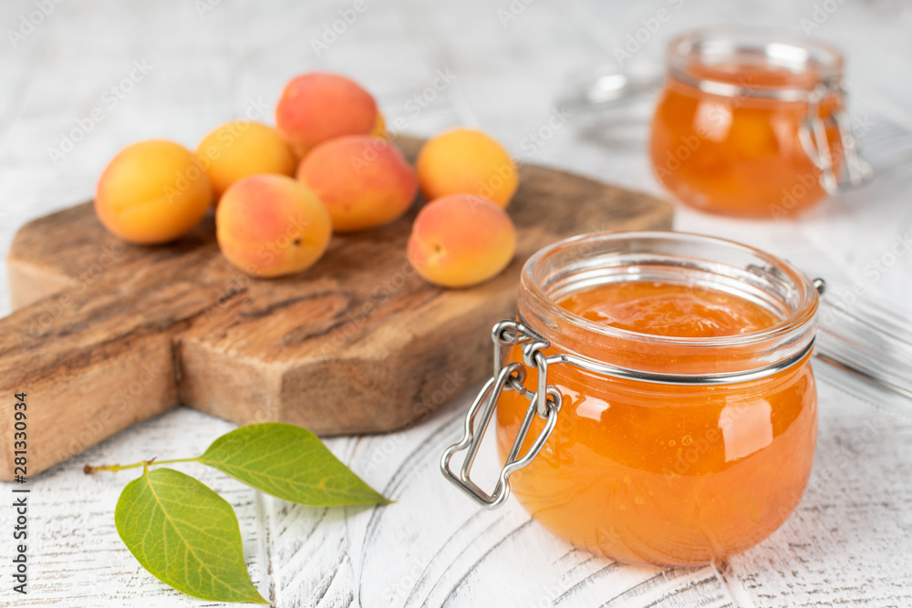 Jars with apricot jam on white wooden background Jars with apricot jam on white wooden background