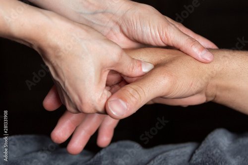 A massage therapist works on releasing tension in a patient's hands.