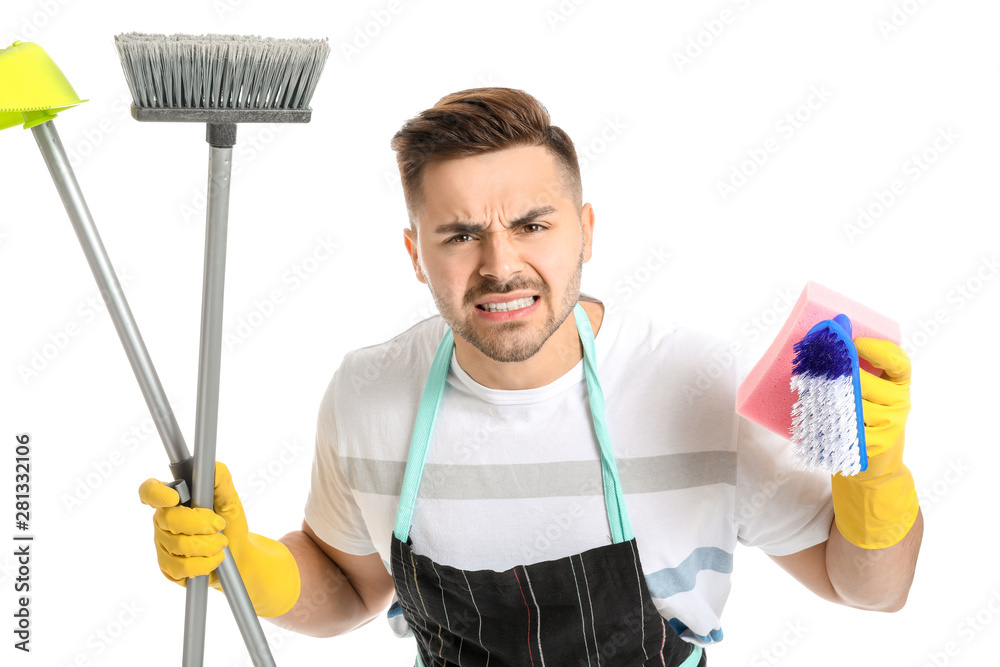 Angry young man with cleaning supplies on white background