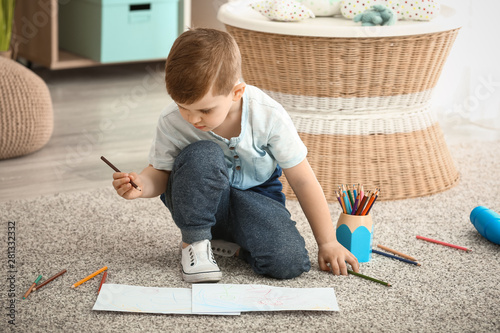 Cute little boy drawing at ...