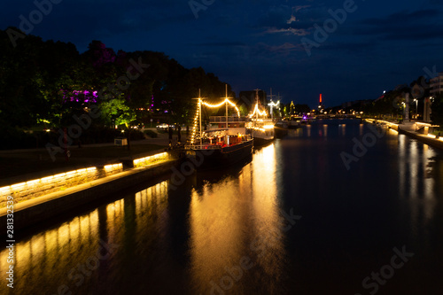 Night view of illuminated restaurant ships with reflection in the water of the river Auraioki  the night landscape of Turku with illumination  the life of the night city. City of Turku  Finland.