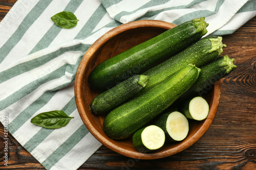 Bowl with fresh zucchini on table