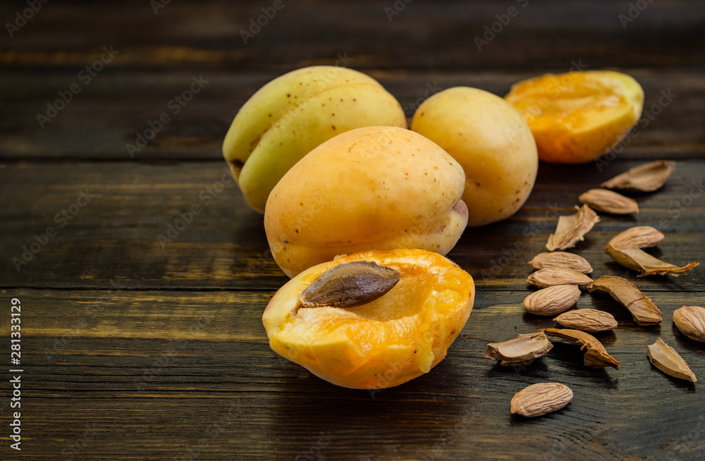 Apricots in a clay plate on a wooden table with broken bones.
