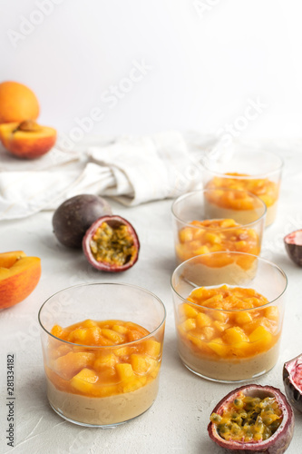 Caramel panna cotta  custard pudding with peach and passion fruit  white table  copy space