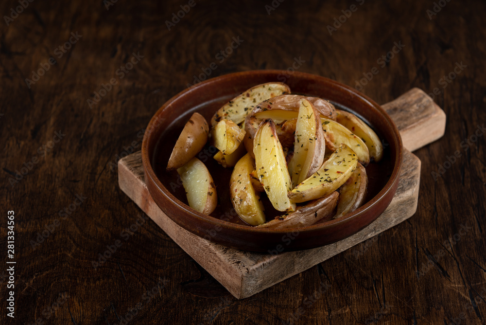 Baked potato in a plate on a wooden background, top view