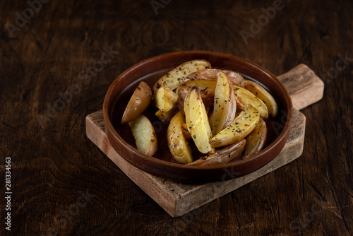 Obraz na płótnie Baked potato in a plate on a wooden background, top view w salonie