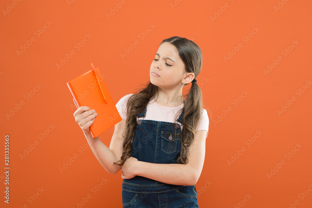 what is this book about. literature lesson. back to school. school girl read book on orange background. poetry and novel. modern education. write notes. kid diary. thinking little girl with notebook what is this book about. literature lesson. back to school. school girl read book on orange background. poetry and novel. modern education. write notes. kid diary. thinking little girl with notebook