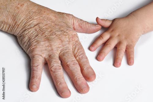 Old grandmother's hand and a young child's hand isolated on white background. Hands isolated on white background