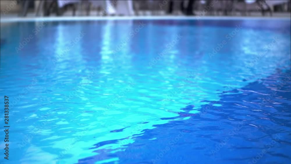 Close-up Shot Of Pool Water features a close-up shot of the clear blue waters of a swimming pool. It appears like the video was taken on a sunny day and the pool looks clean and soothing.