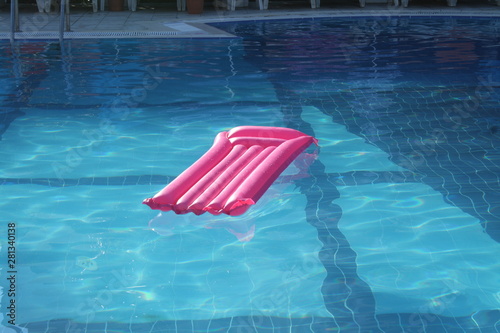 Pink air mattress in the swimming pool on water photo