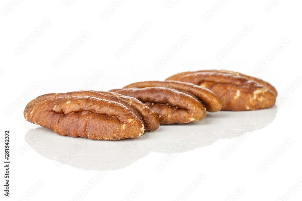 Group of three whole fresh brown pecan nut half in row isolated on white background Group of three whole fresh brown pecan nut half in row isolated on white background