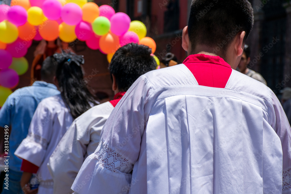 Peregrinación católica con acólitos o monaguillos en una calle de la Ciudad de México