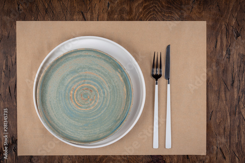 Obraz na płótnie Empty plate with fork and knife on colored wooden background, top view, copy space, mock-up w salonie