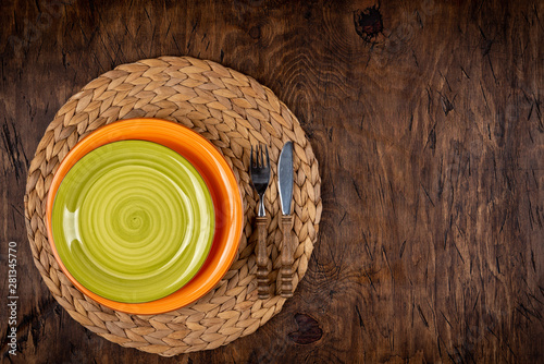 Obraz na płótnie Empty plate with fork and knife on colored wooden background, top view, copy space, mock-up w salonie