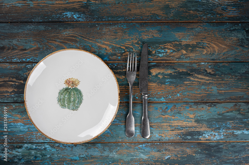 Empty plate with fork and knife on colored wooden background, top view, copy space, mock-up