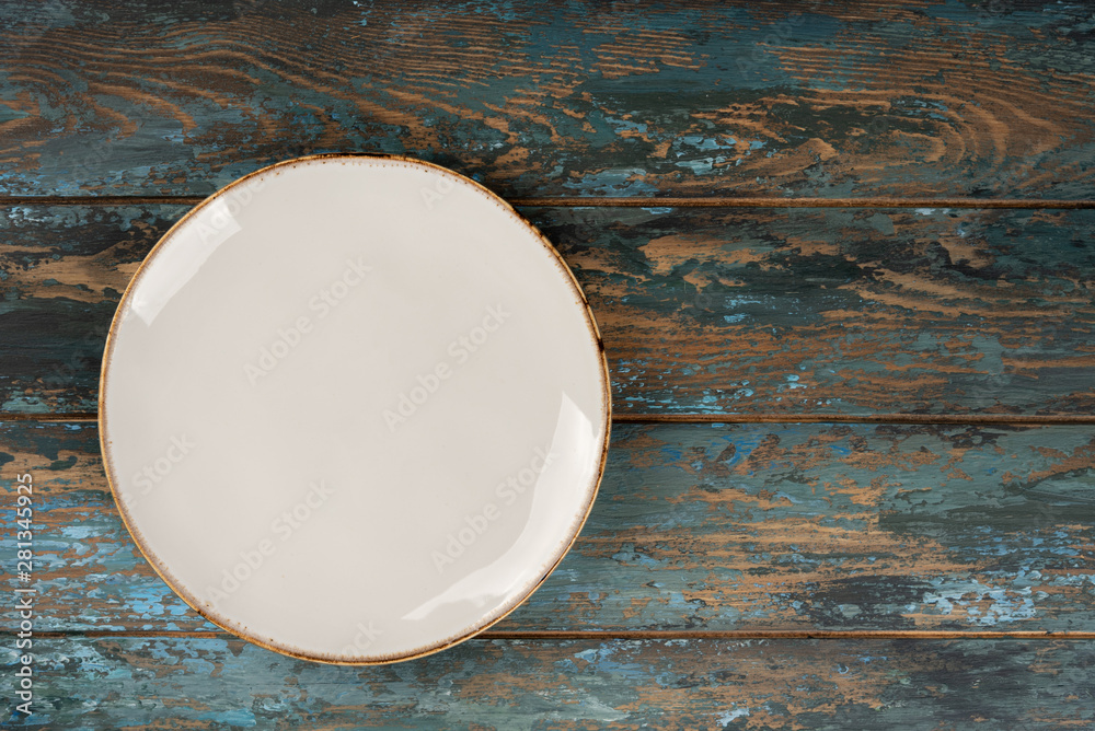 Empty plate with fork and knife on colored wooden background, top view, copy space, mock-up