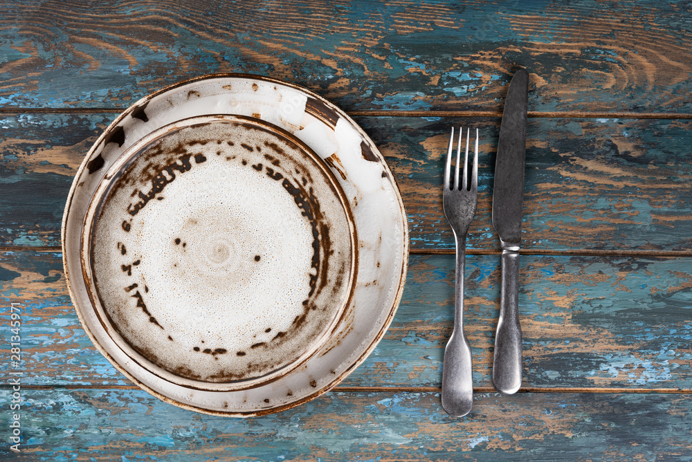 Empty plate with fork and knife on colored wooden background, top view, copy space, mock-up