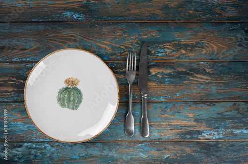 Obraz na płótnie Empty plate with fork and knife on colored wooden background, top view, copy space, mock-up w salonie