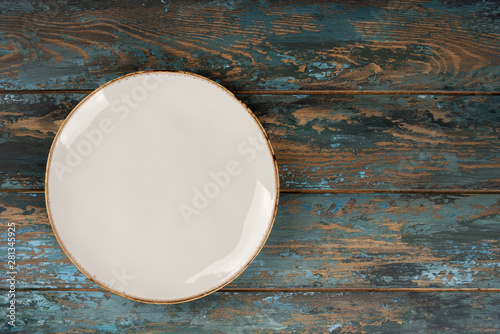 Obraz na płótnie Empty plate with fork and knife on colored wooden background, top view, copy space, mock-up w salonie