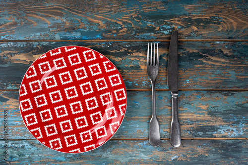 Obraz na płótnie Empty plate with fork and knife on colored wooden background, top view, copy space, mock-up w salonie