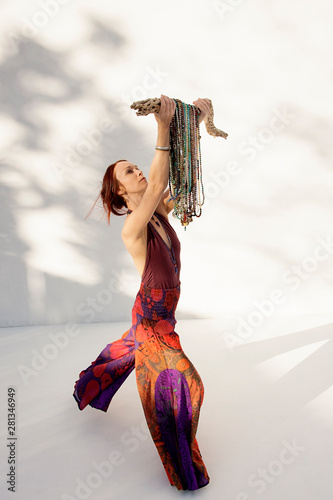 Woman with many yoga mala beads hanging on a cactus bone.  photo