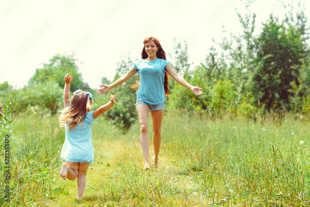 daughter runs towards her mother on the grass