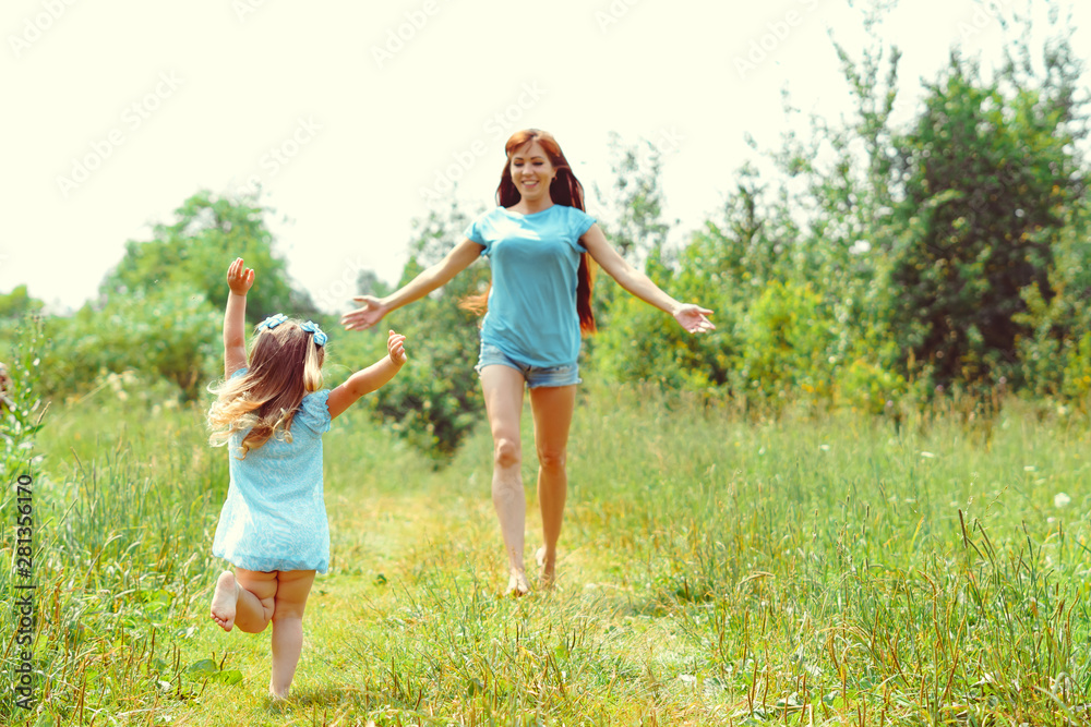 daughter runs towards her mother on the grass daughter runs towards her mother on the grass