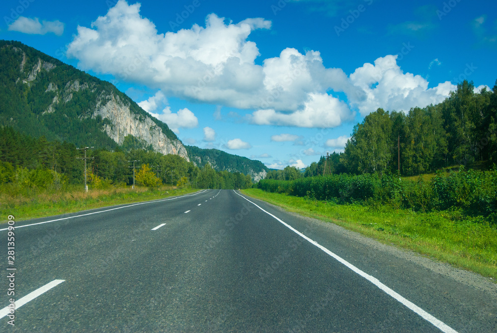 empty asphalt road to horizon near mountains in sunny day