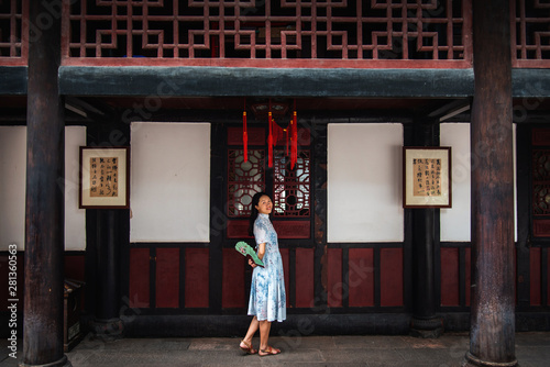 Asian woman in a temple holding a hand fan © creativefamily