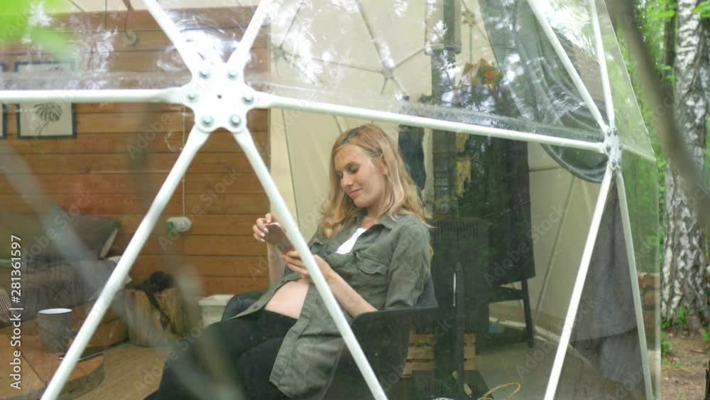 woman uses a phone while sitting in a dome tent woman uses a phone while sitting in a dome tent