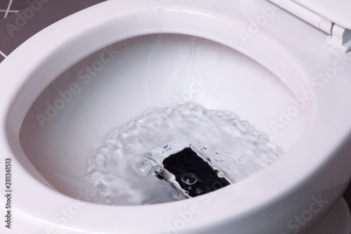 smart phone wet fell in the toilet bowl. White toilet in the bathroom.  © Me studio