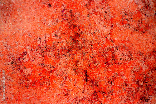 Red rust color facade stone wall with imperfections, holes and cracks as an empty rustic and simple abstract texture surface background.