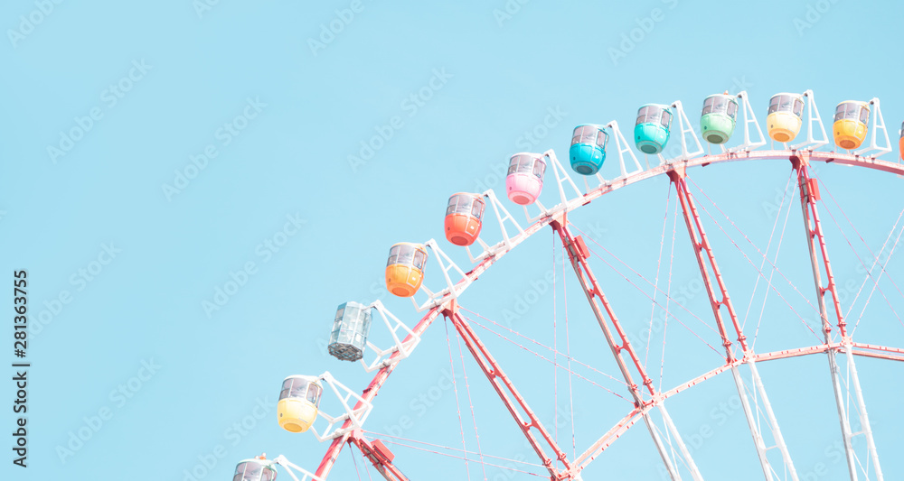 Retro colorful ferris wheel of the amusement park in the blue sky  background.