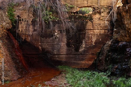 An old dam wall collecting and leaking water in a kloof in South Africa.  photo