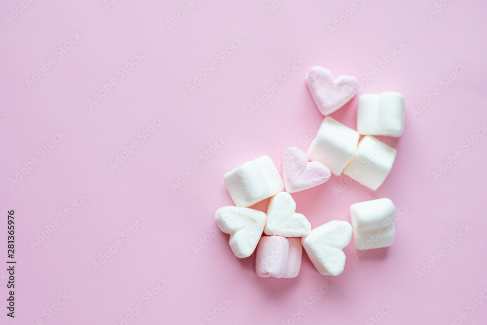 Marshmallows in the shape of pink and white hearts. Heart shaped marshmallows on a pink background. Marshmallows in the shape of pink and white hearts. Heart shaped marshmallows on a pink background.