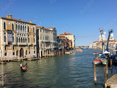 A beautiful early morning view of the Grand Canal in Venice, Italy with water taxis and gondolas past by and the Santa Maria Della Salute in the background.