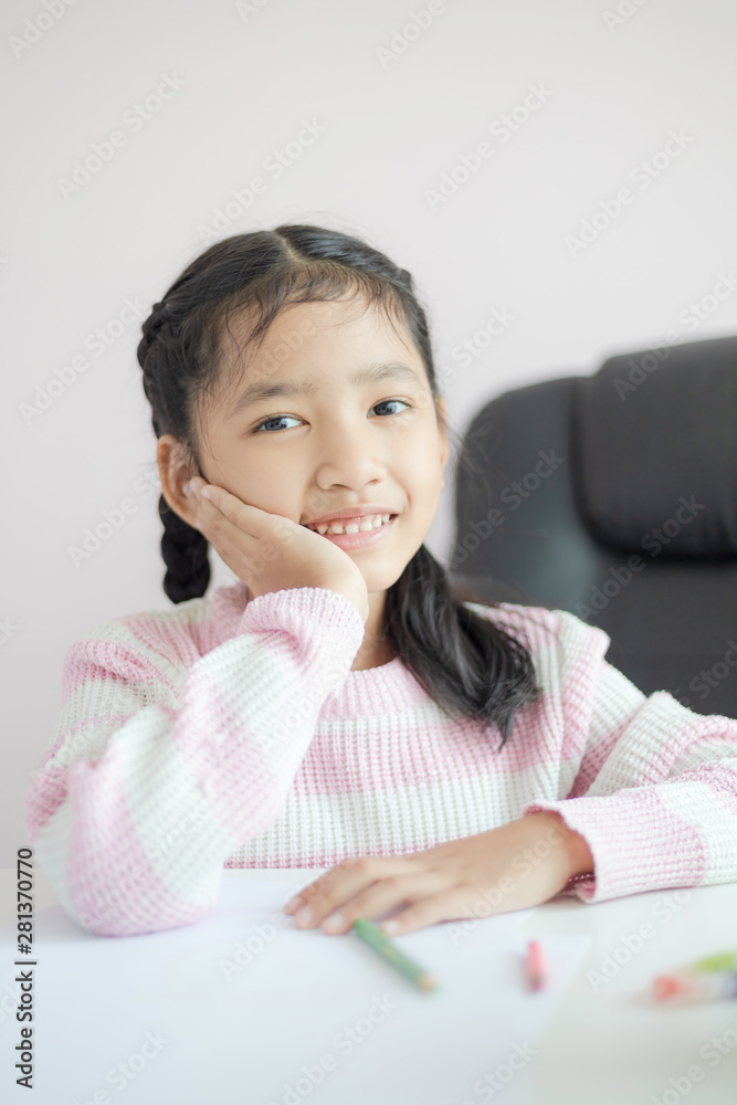 Portrait little Asian girl sitting on the chin and smile with happiness metaphor thinking someting day dreamer concept select focus shallow depth of field Portrait little Asian girl sitting on the chin and smile with happiness metaphor thinking someting day dreamer concept select focus shallow depth of field