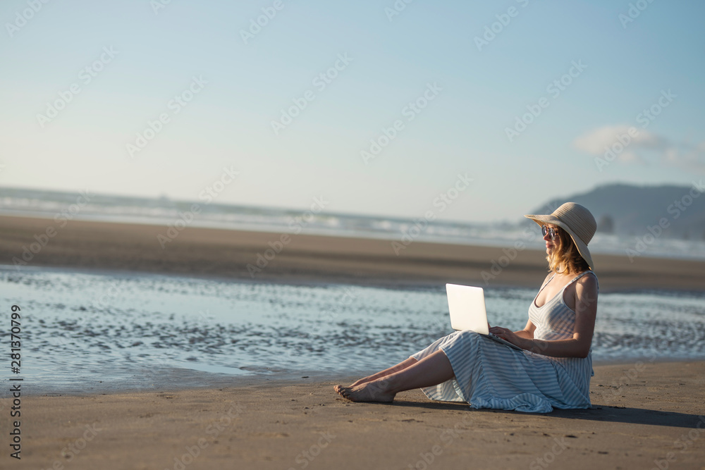 Young girl in sunglasses works on a laptop on the ocean at sunset, freelancing, making money on the Internet, getting money online, lifestyle, Banne, with space