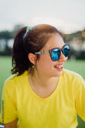 Lovely teen girl street style smiling with sunglasses under sunshine