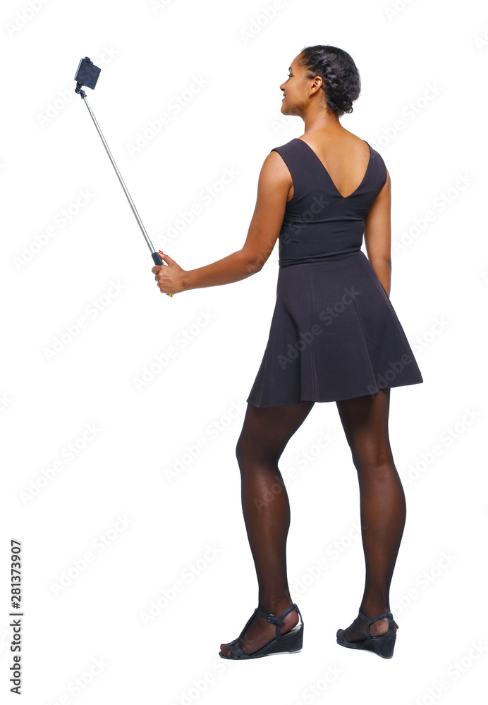 Back view of an African-American woman taking a selfie. Back view of an African-American woman taking a selfie.